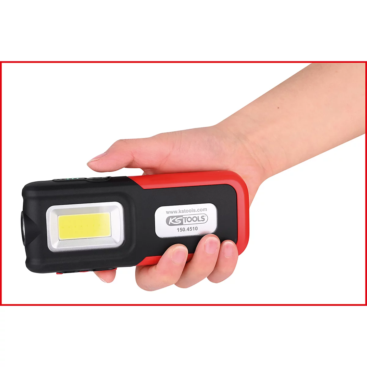 Een hand houdt een zwart-rode LED-werklamp vast. Op de lamp staat een bedrijfslogo en de naam "KS TOOLS".